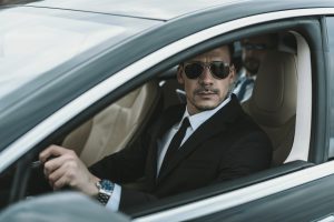 bodyguard-sitting-in-car-with-businessman-and-looking-away.jpg