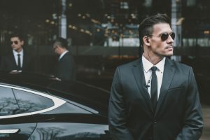 bodyguard-standing-at-businessman-car-and-reviewing-territory.jpg