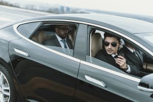 bodyguards-and-businessman-sitting-in-a-black-car.jpg